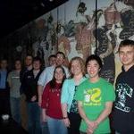 Photo of trombone students in front of restaurant mural at dinner at during Winter 2010.